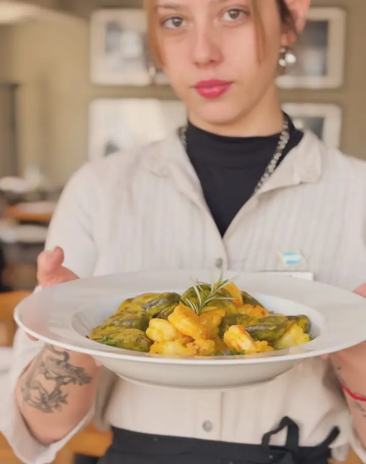 Una moza del Ideal sirve un plato de pastas